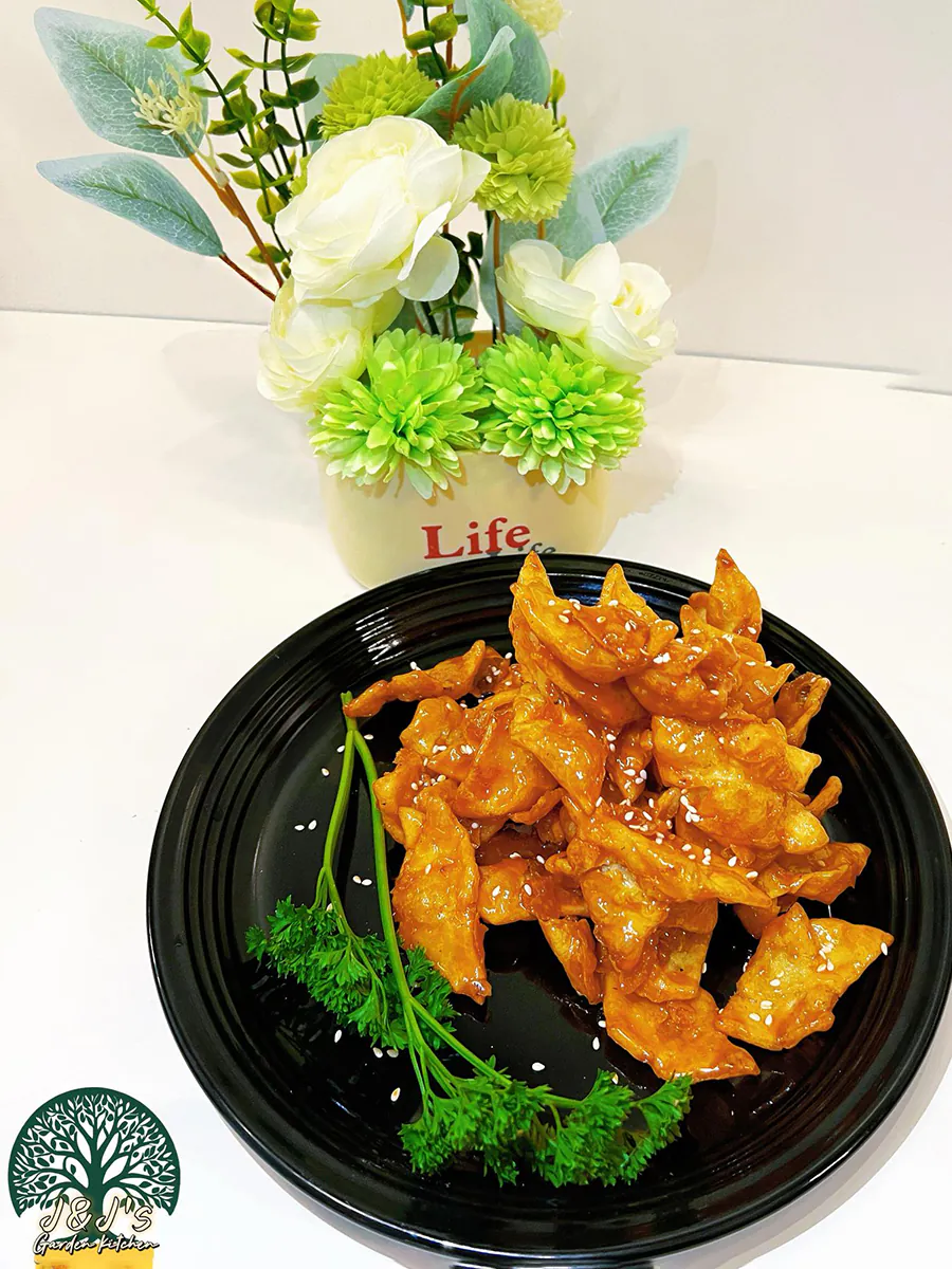 Crispy glazed fried dumplings garnished with sesame seeds and parsley at J&J's Garden Kitchen，a Asian Restaurant in Fredericksburg