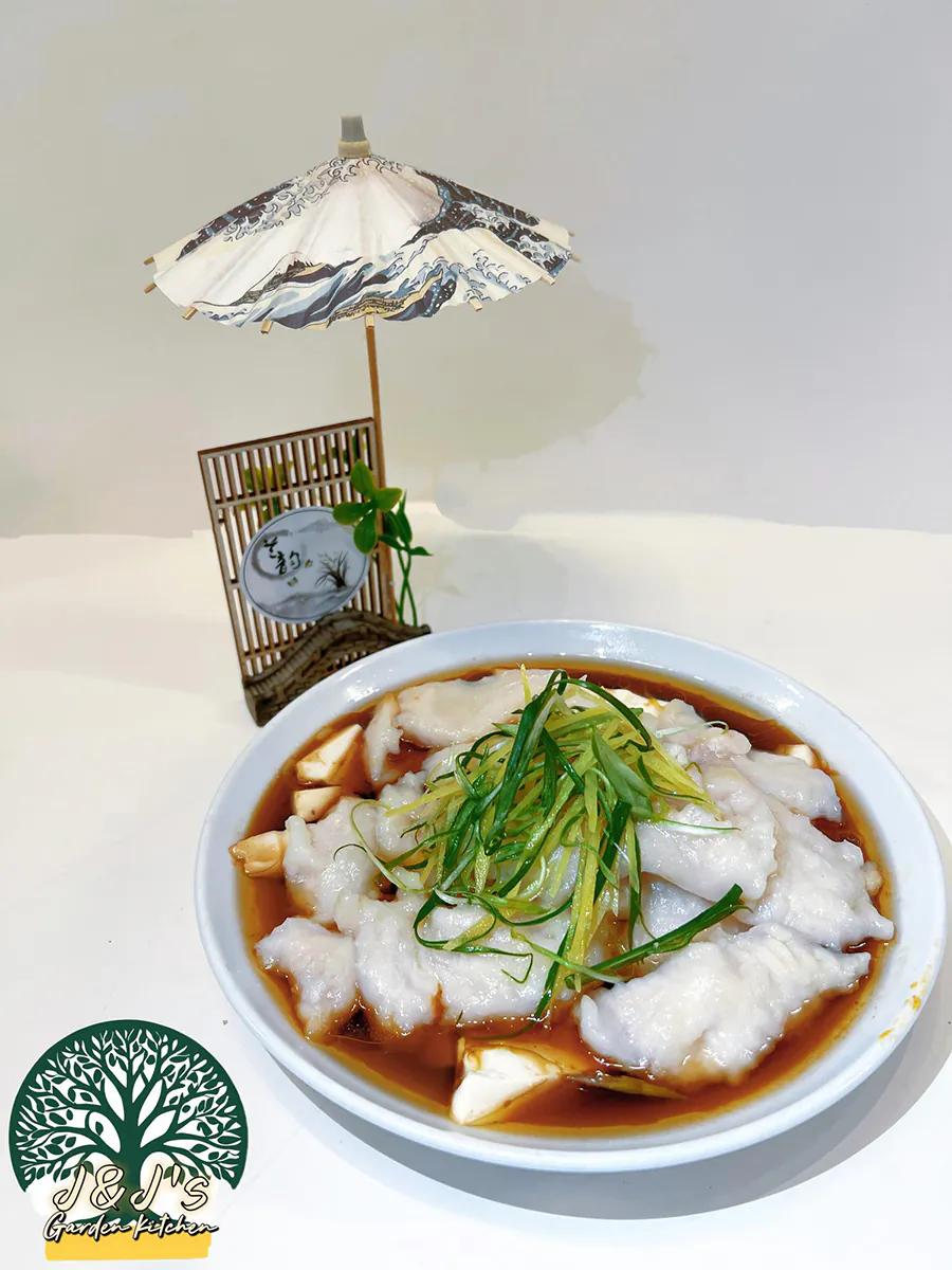 Steamed fish fillet with tofu in a savory soy sauce broth, topped with green onions at J&J's Garden Kitchen，a Asian Restaurant in Fredericksburg